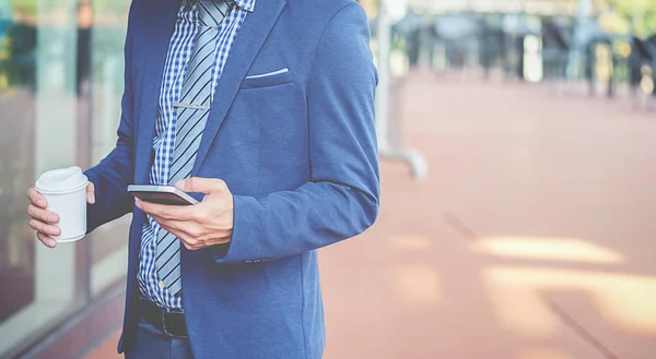 Handsome Young Businessman Holding His Laptop While Using His Phone — Stock Photo, Image