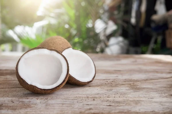 Meia maduro corte de coco em um fundo de madeira. Creme de coco e — Fotografia de Stock