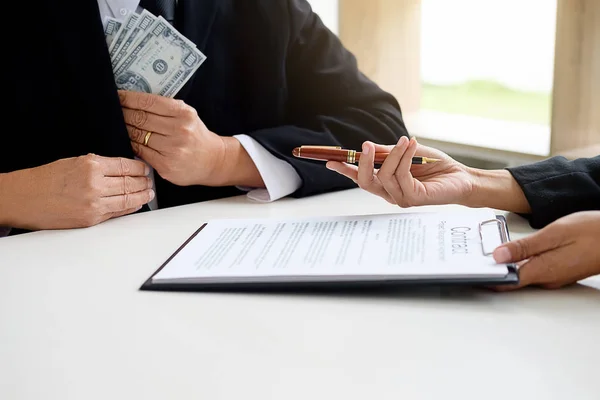 Businessman in suit hides money. A bribe in the form of dollar b — Stock Photo, Image