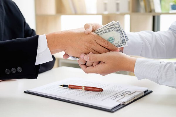 Бизнесмен в костюме прячет деньги. Взятка в виде доллара b
