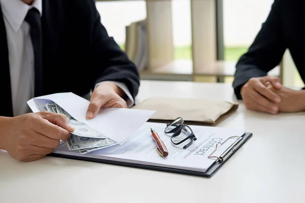 Businessman in suit hides money. A bribe in the form of dollar b — Stock Photo, Image