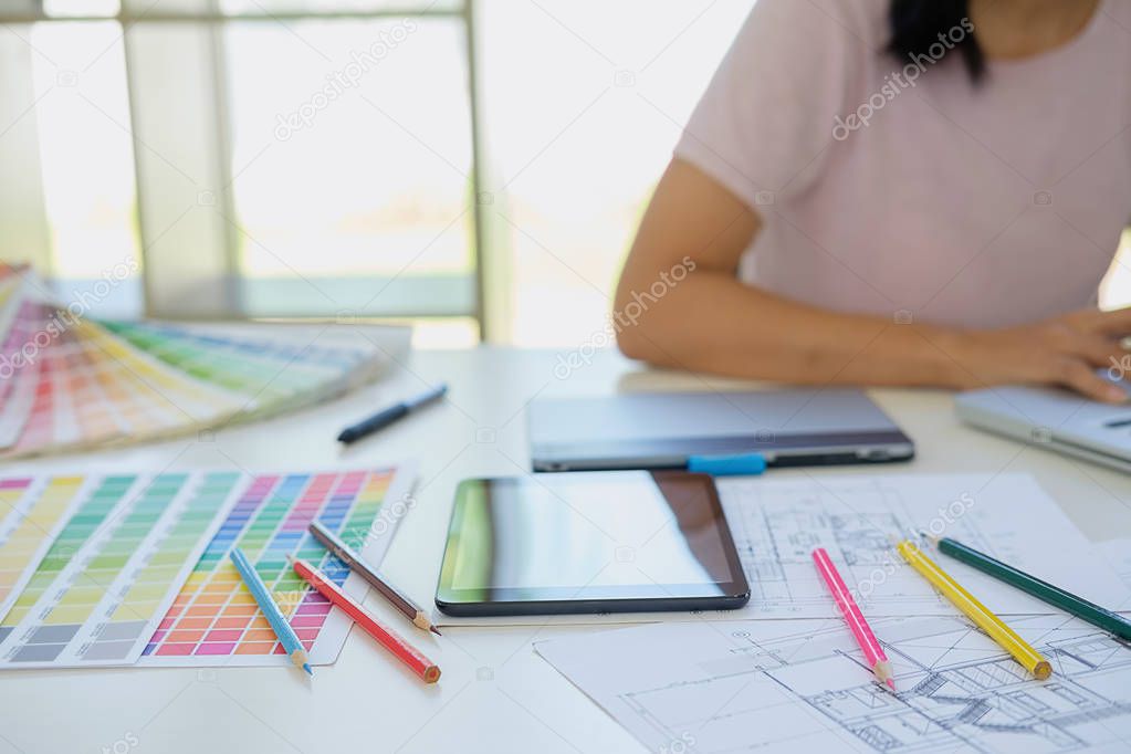 Graphic design and color swatches and pens on a desk. Architectu