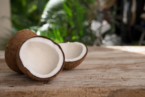 Coco maduro medio cortado sobre un fondo de madera. Crema de coco y —  Fotos de Stock