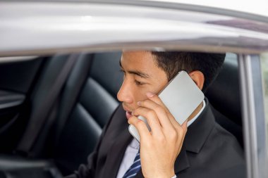 Bir arabanın arka koltuğunda oturan başarılı iş adamı 