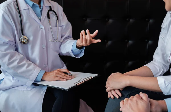 Paciente ouvindo atentamente um médico do sexo masculino explicando paciente s — Fotografia de Stock