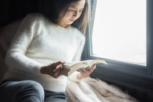 Читаю книгу. Красивая женщина сидит на кровати и читает — стоковое фото
