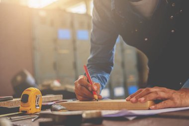 Marangoz marangozluk dükkanda ahşap işleme makineleri üzerinde çalışıyor. WOM