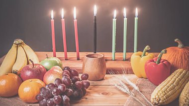 Kwanzaa tatil konseptiyle dekore yedi mum kırmızı, siyah bir