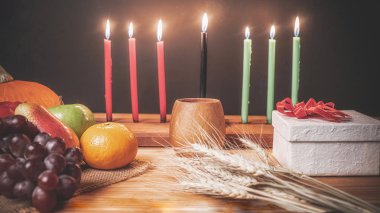Kwanzaa tatil konseptiyle dekore yedi mum kırmızı, siyah bir