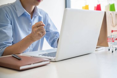 Kredi kartı tutan ve dizüstü bilgisayar kullanan genç kadın. No