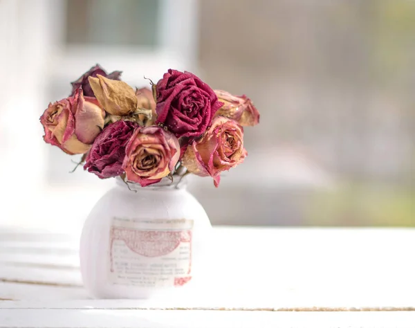 White vase with flowers on the table