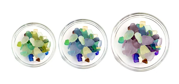 Guijarros de colores en una taza de vidrio sobre fondo blanco — Foto de Stock