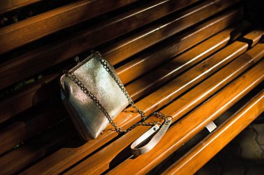 Kadınlar, ahşap bankın üzerinde yalan için güzel çanta