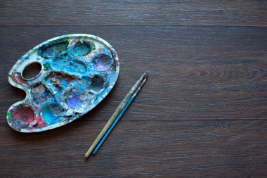 Resim paleti ve ahşap arka plan boyama için fırçalar. Üstten Görünüm.