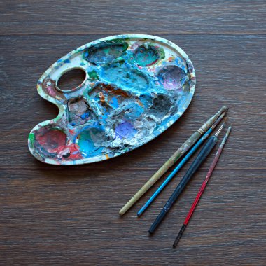 Resim paleti ve ahşap arka plan boyama için fırçalar. Üstten Görünüm.