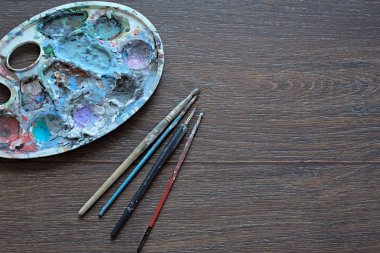 Resim paleti ve ahşap arka plan boyama için fırçalar. Üstten Görünüm.