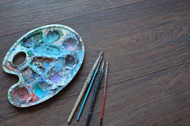 Resim paleti ve ahşap arka plan boyama için fırçalar. Üstten Görünüm.