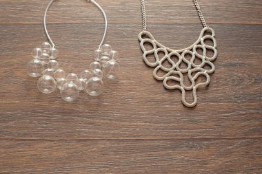 Ahşap koyu arka plan üzerinde kadınlar için iki güzel Kolyeler.