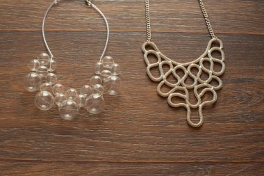 Ahşap koyu arka plan üzerinde kadınlar için iki güzel Kolyeler.