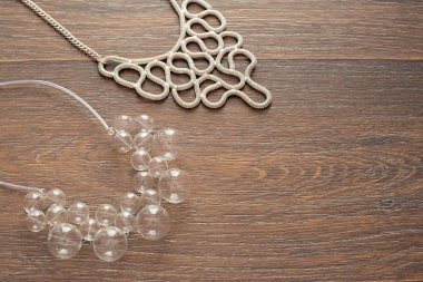 Ahşap koyu arka plan üzerinde kadınlar için iki güzel Kolyeler.