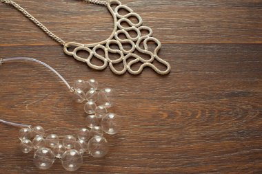 Ahşap koyu arka plan üzerinde kadınlar için iki güzel Kolyeler.