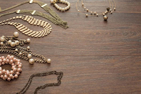Dekorativa sammansättning av kvinnors smycken på trä mörk bakgrund. — Stockfoto