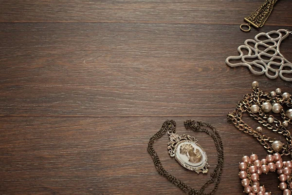 Vintage sammansättning ligga platt smycken för kvinnor på trä bakgrund. — Stockfoto