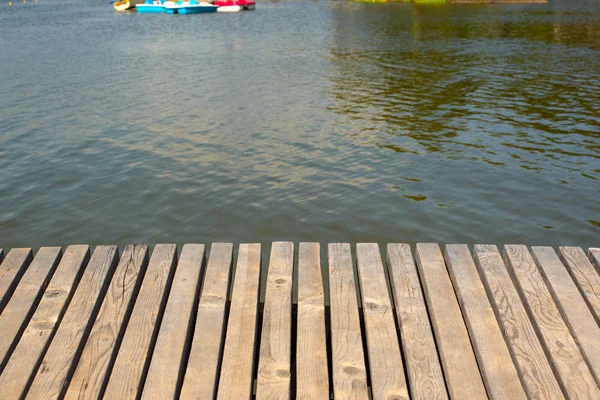 Vintage-Holztisch auf dem Hintergrund eines verschwommenen Wasserhintergrunds. — Stockfoto