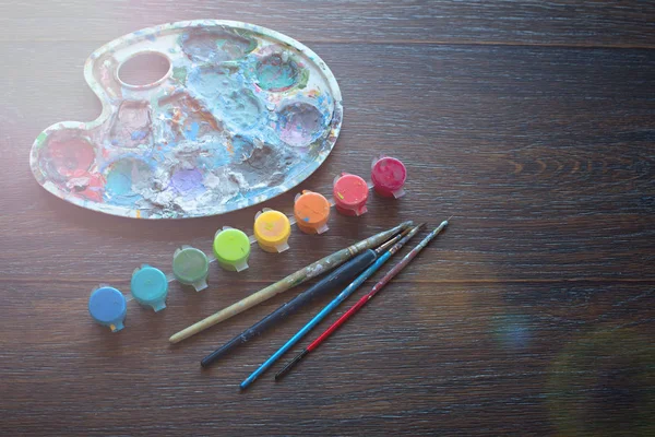 Sanat hazır, palet, boya, fırçalar ahşap arka plan üzerinde.