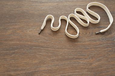 Ahşap koyu arka plan üzerinde beyaz bir kordon.