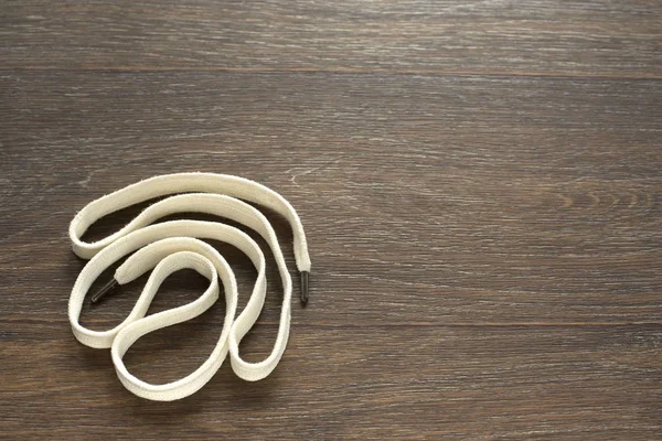 Ahşap koyu arka plan üzerinde beyaz bir kordon.
