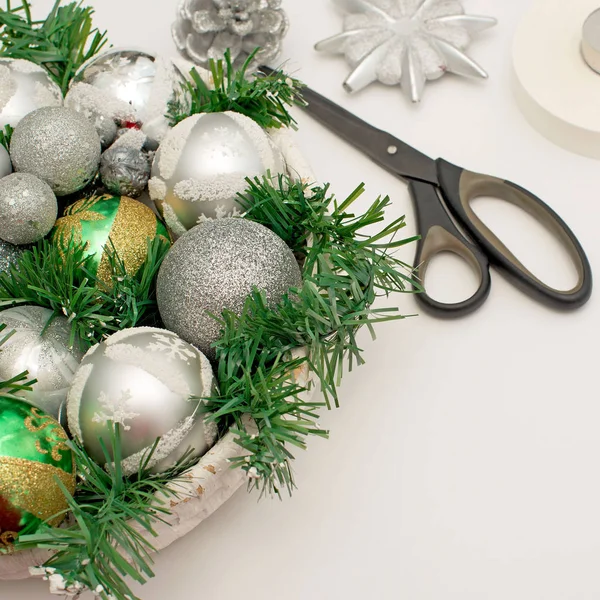 Un arreglo navideño festivo ramas artificiales, bolas de vidrio en la cesta . — Foto de Stock