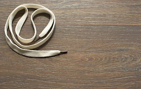 Ahşap koyu arka plan üzerinde beyaz bir kordon.