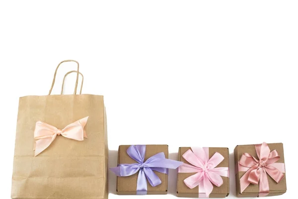 Три святкові коробки з подарунками, пов'язаними атласною стрічкою на білому тлі . — стокове фото