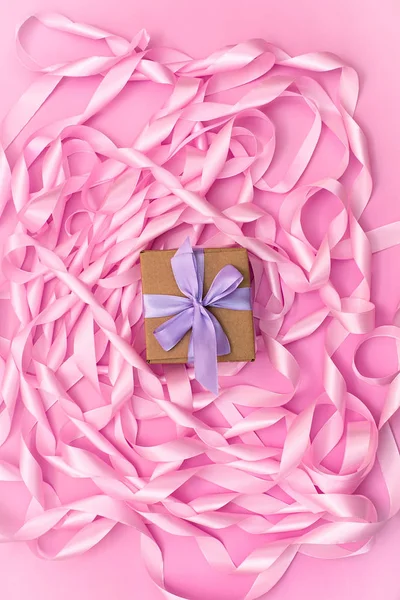 Schachteln mit Geschenken auf dem Hintergrund einer Spule aus dekorativen Satinbändern in rosa Farbe. — Stockfoto
