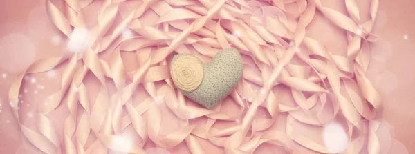 Transparent włókienniczych serca na tle cewki dekoracyjne wstążki satynowe, kolor różowy. — Zdjęcie stockowe