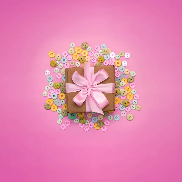 Decorative background with colored buttons in bulk and gift box.