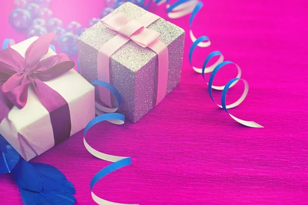 Schachteln mit Geschenken auf leuchtend rosa Hintergrund. — Stockfoto
