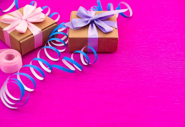 Boxes with gifts on a bright pink background.