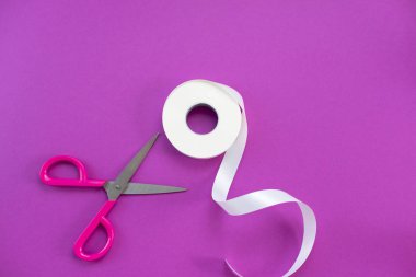 Makas ve rulo bant beyaz mor bir arka plan üzerinde. Yaratıcılık, Hobiler ve tasarım malzemeleri. Düz yatıyordu Üstten Görünüm