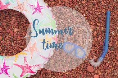 Deniz çakıl üzerinde afiş plaj aksesuarları.