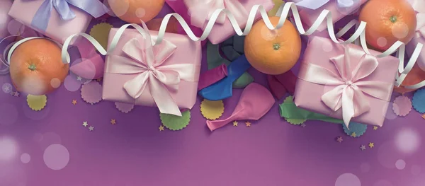 Transparent trzy pola dekoracyjnych kompozycji z darów wstążka satynowa kokarda pomarańcze konfetti serpentyn urodziny. — Zdjęcie stockowe