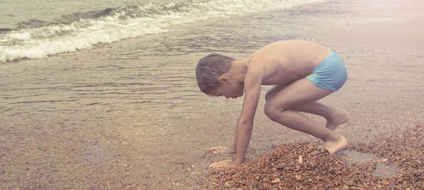 Баннер красивый забавный мальчик играет на берегу моря — стоковое фото