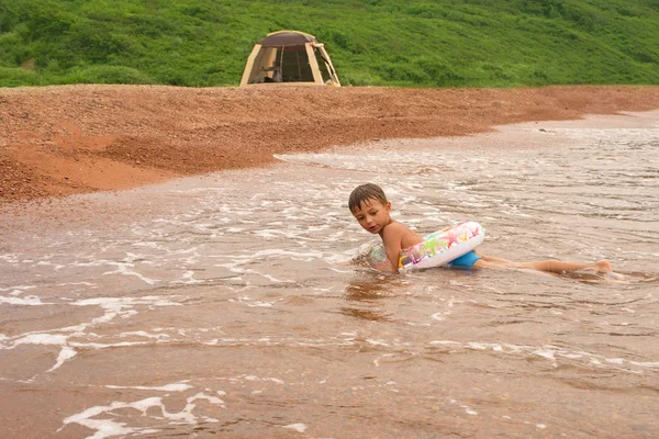 Красивый веселый мальчик, играющий на берегу моря — стоковое фото