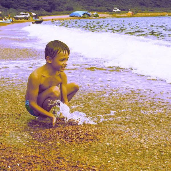 Surrealism beautiful funny boy playing on the seashore — Stock Photo, Image