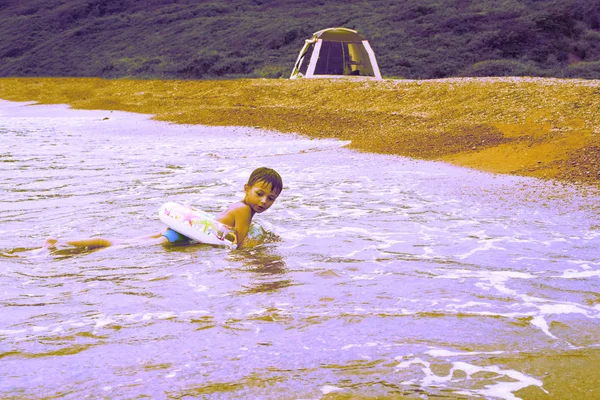 Surrealismo bello divertente ragazzo giocare sulla riva del mare — Foto Stock