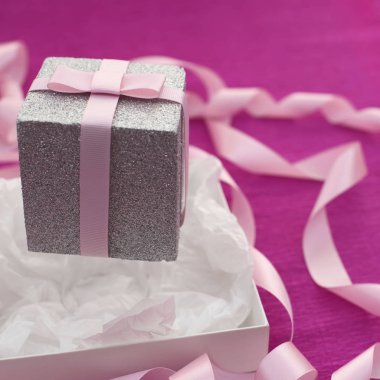 Parlak pembe bir arka plan üzerinde hediye kutusu ile şenlikli kompozisyon.