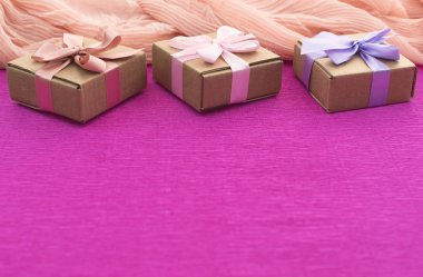 Festival kompozisyon üç Kraft kutu parlak pembe bir arka plan üzerinde hediyeler ile.