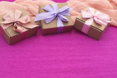 Festival kompozisyon üç Kraft kutu parlak pembe bir arka plan üzerinde hediyeler ile.