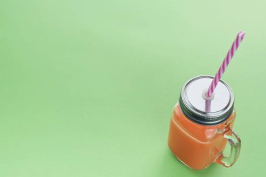 Cam bardak yeşil zemin üzerine saman ile doğal taze iç Smoothies.